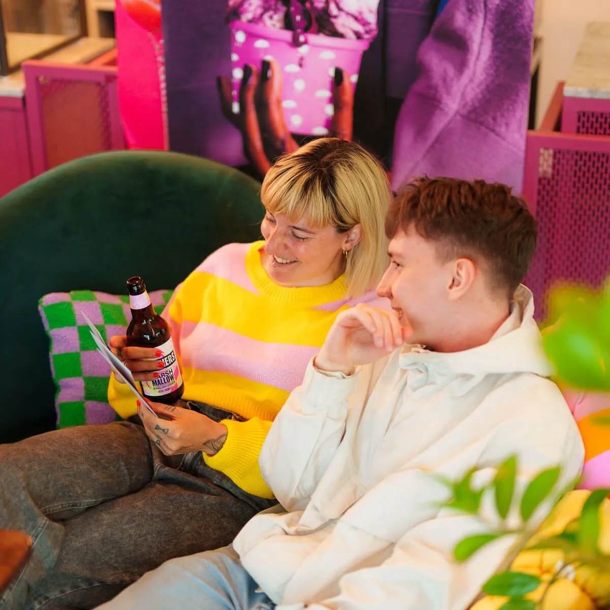 Two people enjoying drinks at a vibrant Creative Lunch Club meetup in Amsterdam, seated in a colorful lounge setting.