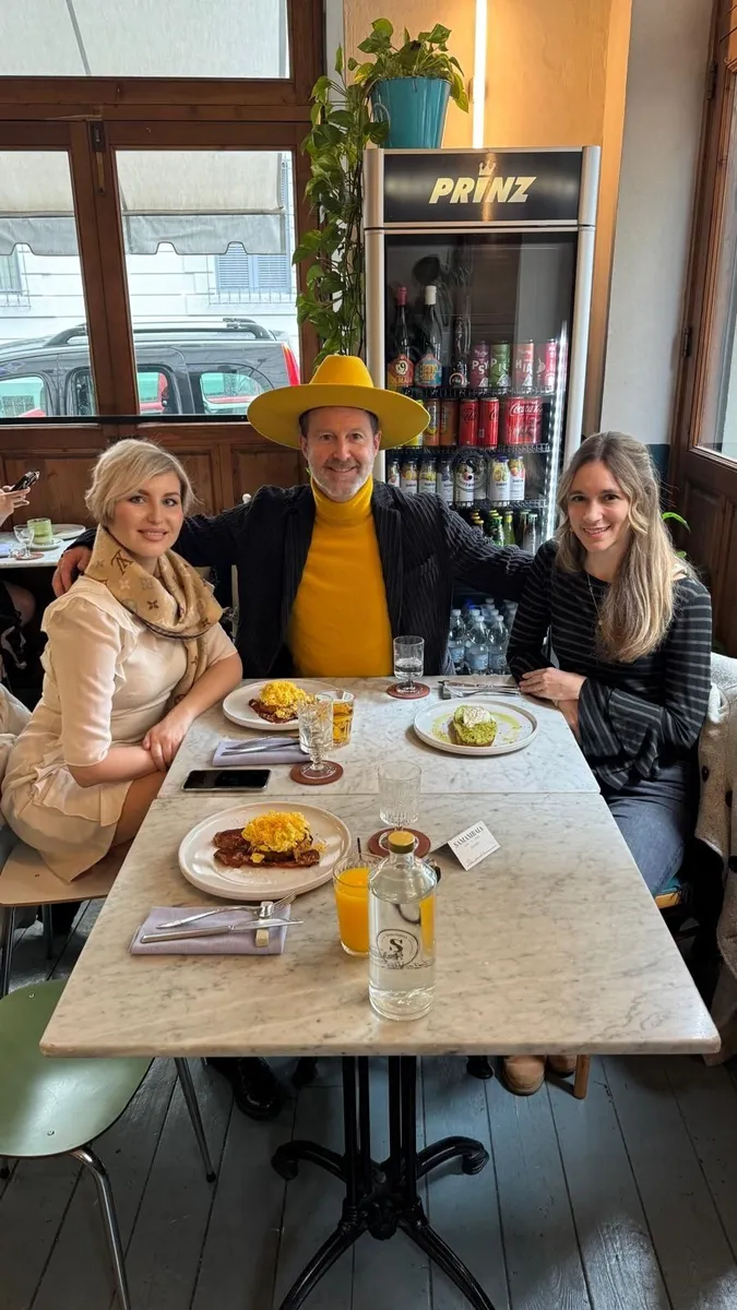 Three people dining at a marble table in a Florence restaurant with a PRINZ refrigerator visible in the background.
